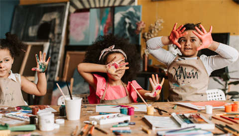 Young kids paining with paint over hands
