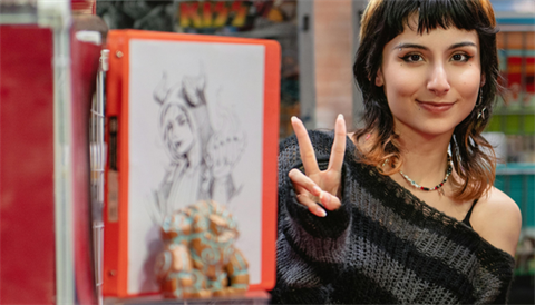 Young teen posing with manga drawing
